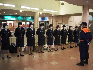 制服を着た女性消防団が横一列に並び、市長と向かい合っている写真