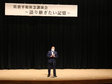 舞台上で、マイクの前に立つ市長の写真