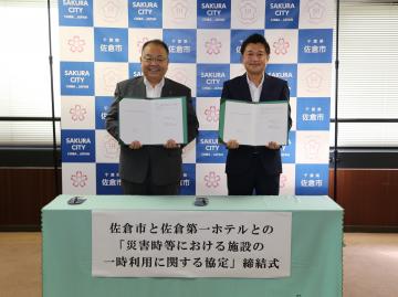 佐倉第一ホテルとの「災害時等における施設の一時利用に関する協定」締結式にて、協定書を持った市長と男性が横にならんでいる写真