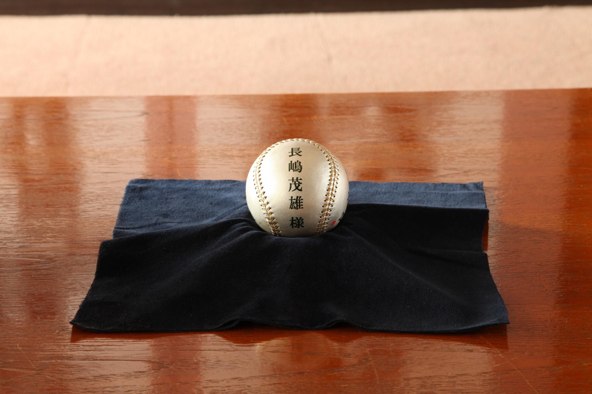 長嶋茂雄様と書かれた銀色のボールが、黒い布の上に置かれている写真