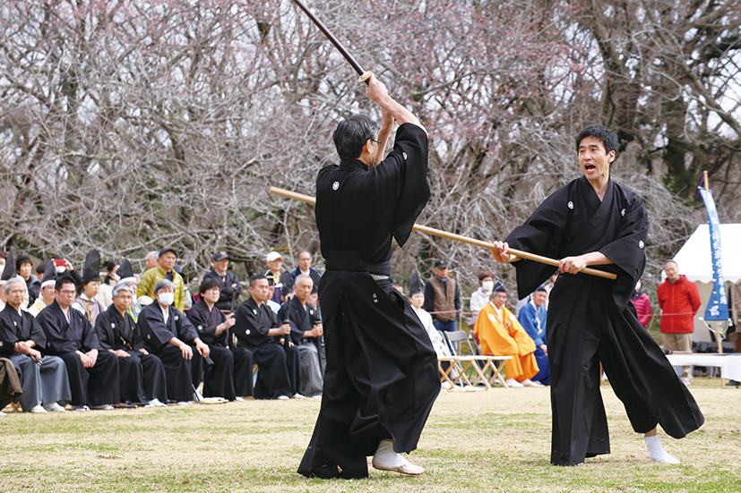 男性2名が長い棒を手に立見流の演武を披露している写真