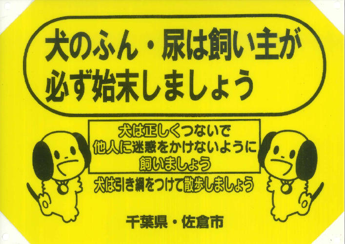 「犬のふんは飼い主が必ず持ち帰りましょう 犬は正しくつないで他人に迷惑をかけないように飼いましょう 犬は引き綱をつけてさんぽしましょう 千葉県・佐倉市」の文字と2匹の犬のイラストが描かれた看板