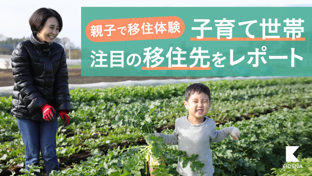 畑で収穫した大根を持っている男の子とそれを見て笑っている母親の写真