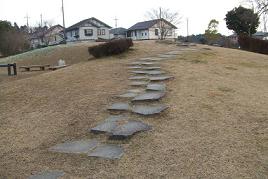 住宅地に囲まれた園内にある、なだらかな丘へ登る石の階段を下から撮影した写真