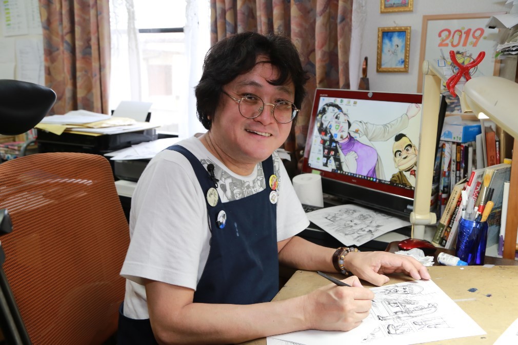 漫画を執筆中の漫画家 木村直巳さんの写真