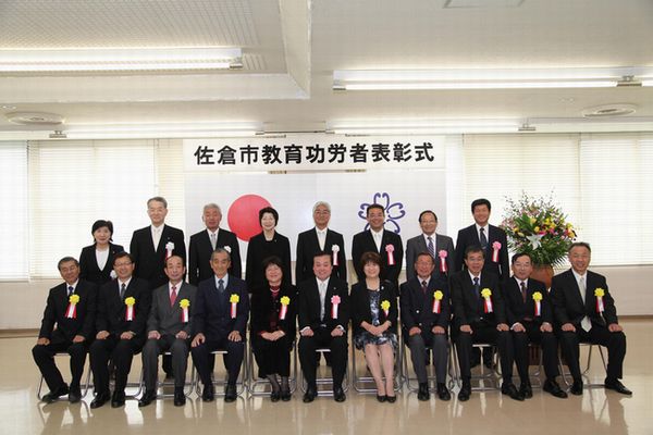 前列に11名、後列に8名の胸章リボンをつけた方々の集合写真
