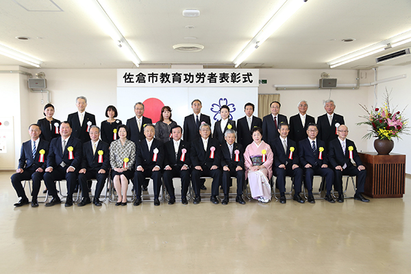 前列に12名、後列に11名の胸章リボンをつけた方々の集合写真
