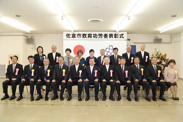前列に11名、後列に9名の胸章リボンをつけた方々の集合写真