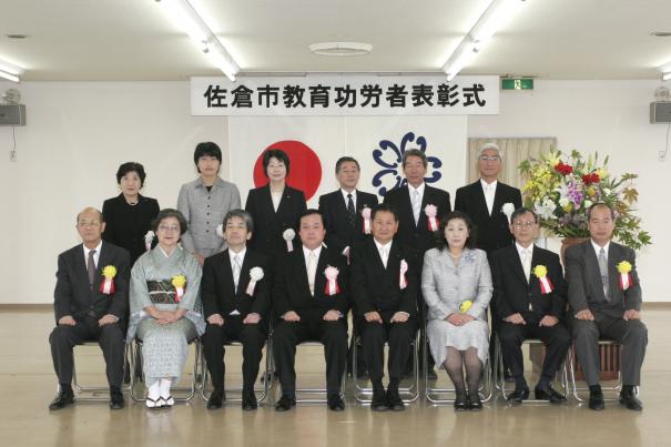 前列に8名、後列に6名の胸章リボンをつけた方々の集合写真