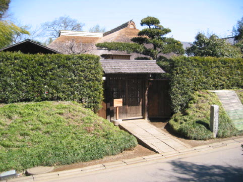 門の両脇に木々が植えられた旧河原家住宅の入り口を写した写真