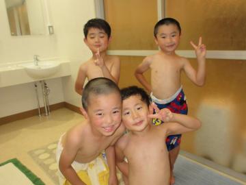脱衣所で、タオルを巻いた男の子の園児4名が、ポーズを取っている写真