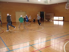 体育館の中で床の枠の中に入って遊んでいる子どもたちの写真