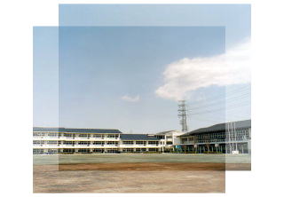 南側より撮影された、佐倉市立根郷中学校の校庭および校舎の遠景写真