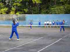 10人ほどの女子生徒がテニスコートで練習している写真