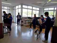 8人の男女の生徒が楽器の練習をしている写真