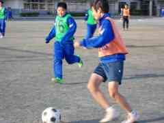 男子生徒がサッカーボールを蹴ろうとしている写真