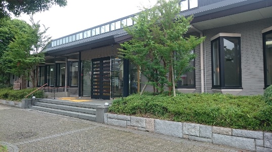 建物前には樹木が植えられ、玄関前に3段の階段があり、タイル調の外壁で三角の出窓が並んでいる千代田・染井野ふれあいセンターの外観写真