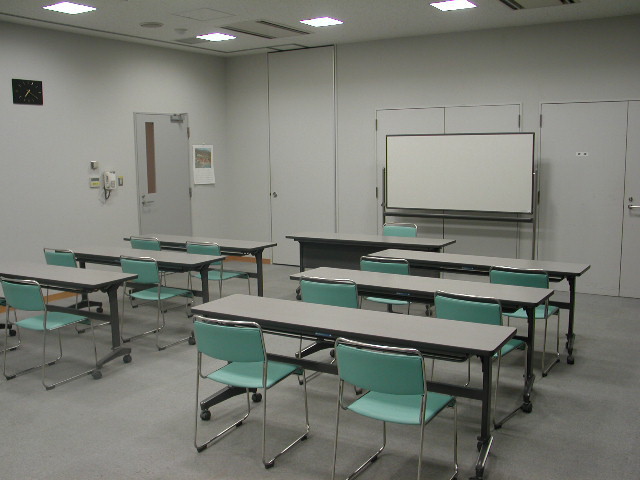 前方にホワイトボードがあり、2人掛けの長机が2列に並んでいる第3会議室の写真