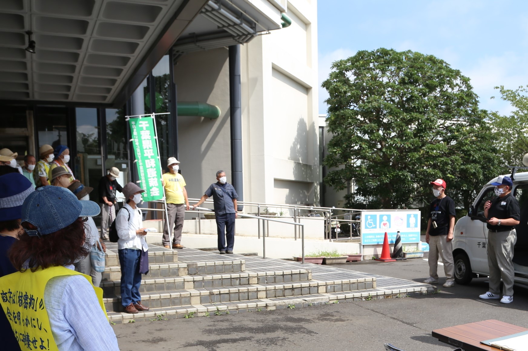 2021原水爆禁止国民平和大行進で、階段周辺に集まる参加者が、白いワゴンの前に立って話をする市長を注目している写真
