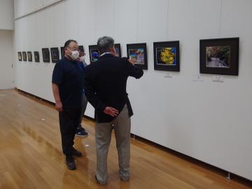 佐倉公募写真展2021で、作品を見ながら話をしている市長と関係者の写真