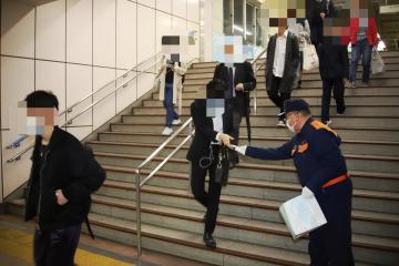 階段を下りてくる通行人に、チラシを配っている市長の写真