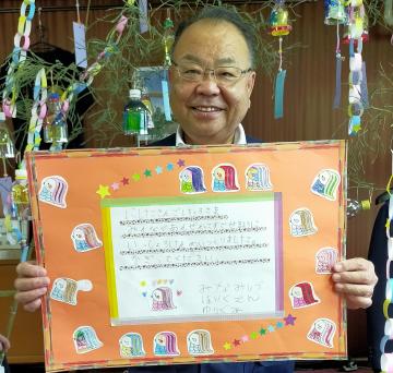 色が塗られたアマビエや飾り付けられたメッセージカードを笑顔で持つ市長の写真