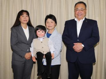 人形のあっちゃんを持つ女性2名と、市長が並んでいる写真