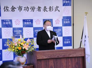 佐倉市功労者表彰式にて、演台に立ち挨拶をしている市長の写真