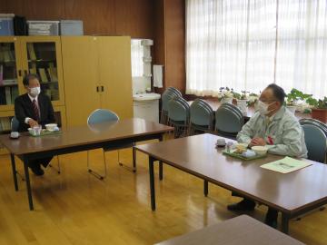 市長と男性が着席する席に、給食が置かれている写真