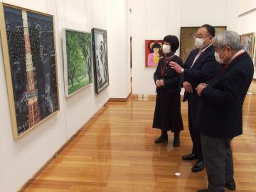 市長と、男女2名が壁に掛けられた絵画を見ている写真