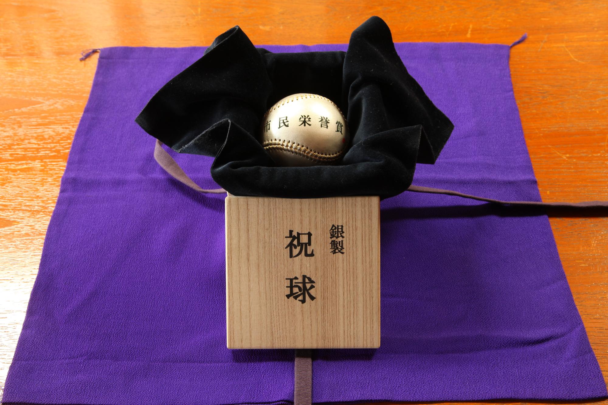 市民栄誉賞と書かれた銀色のボールが、銀製 祝球と書かれた木箱の中に収められている写真