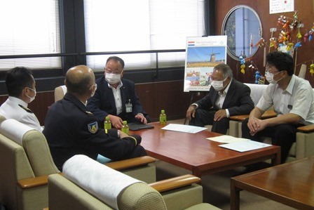 会議室で、市長、制服を着た男性や関係者が座って話をしている写真