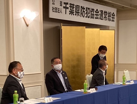 千葉県防犯協会総会で、青い布がかけられた席に着席している市長や関係者2名の写真