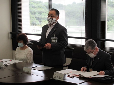 佐倉市赤十字奉仕団役員会にて着席している男女の間で、資料を持って立っている市長の写真