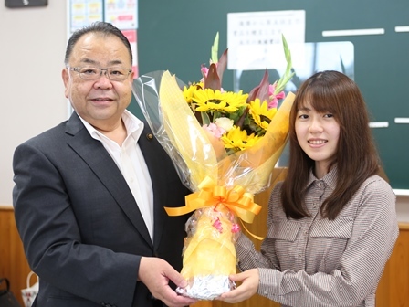 小高佐季子棋士と、市長がひまわりの花束を一緒に持っている写真