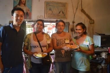 稲葉健一さんと食べ物が乗ったお皿を持っている女性3人と記念撮影をしている写真