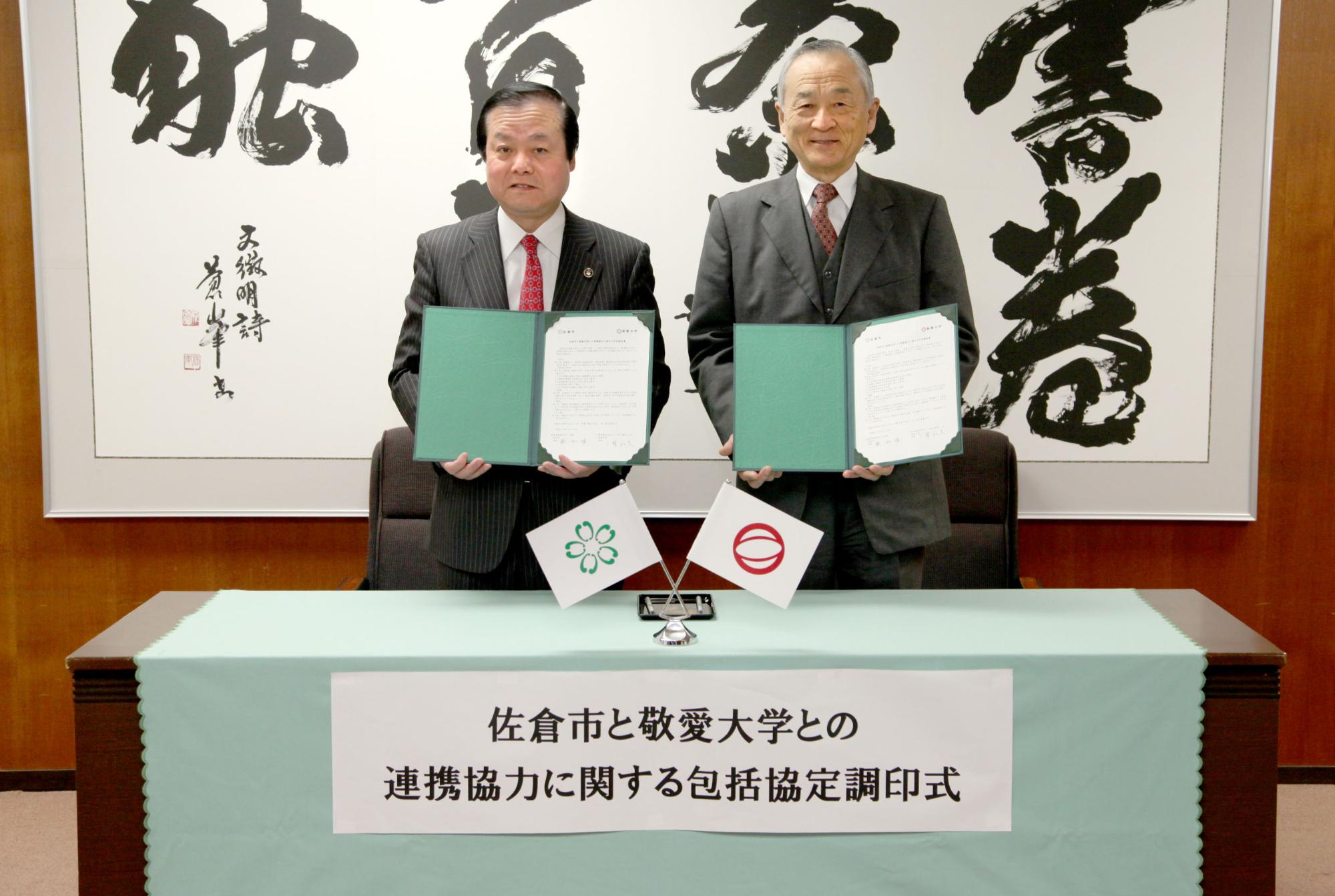 蕨市長と敬愛大学 三幣学長が協定書を手に持ち笑顔で撮影している写真