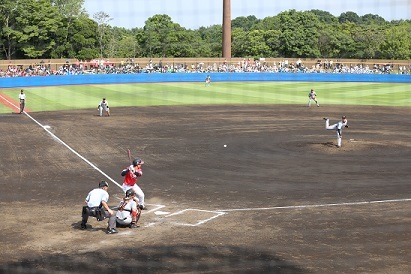 ピッチャーが投げたボールをバッターが打とうとしている試合のマウンド全体を写した写真