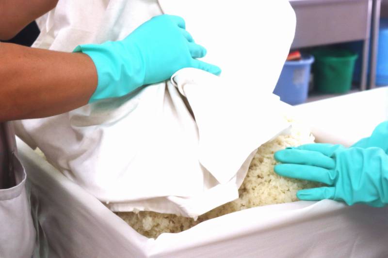 麹菌がついたお米を木箱に入れています。