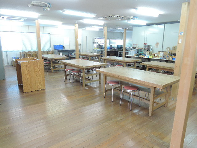 6つの大きな作業台が設置されている実習室の写真