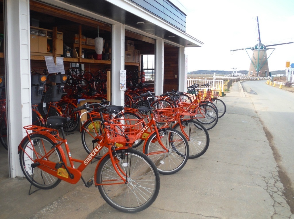 オレンジ色のレンタル自転車が並んでいる写真