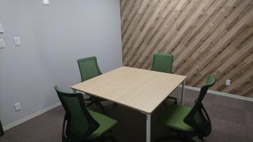 会議室に机と椅子が4脚設置してある写真
