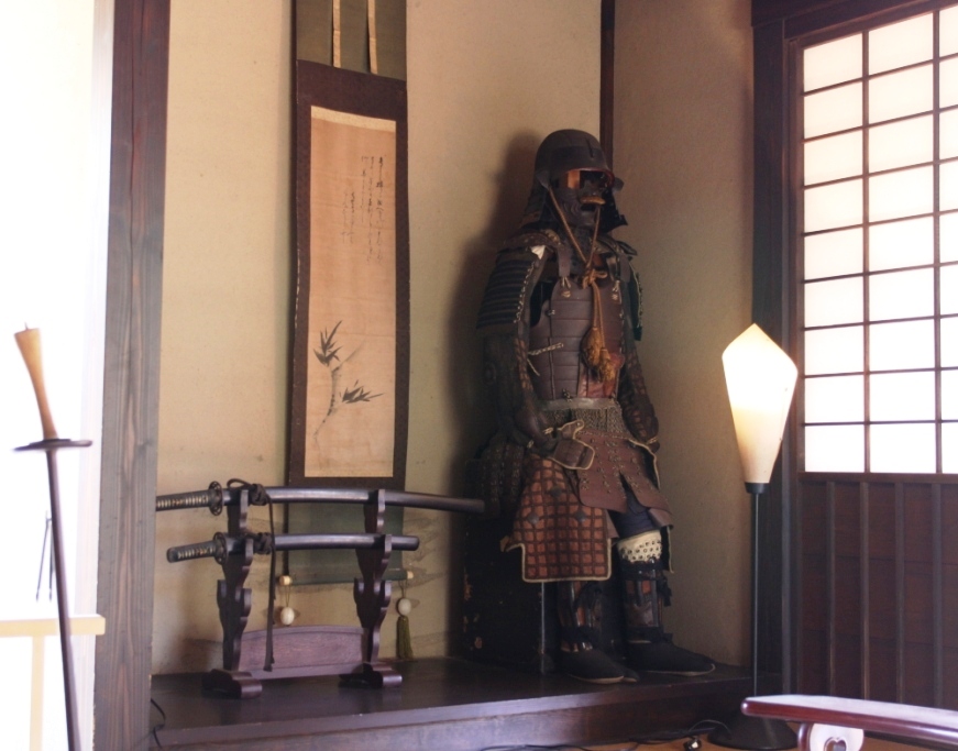 武家屋敷内の床の間に掛け軸・刀・甲冑が飾ってある写真
