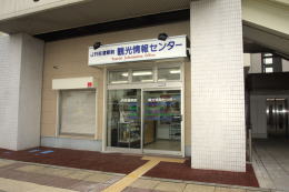 ガラス扉の上に看板を掲げているJR佐倉駅前観光情報センターの外観の写真