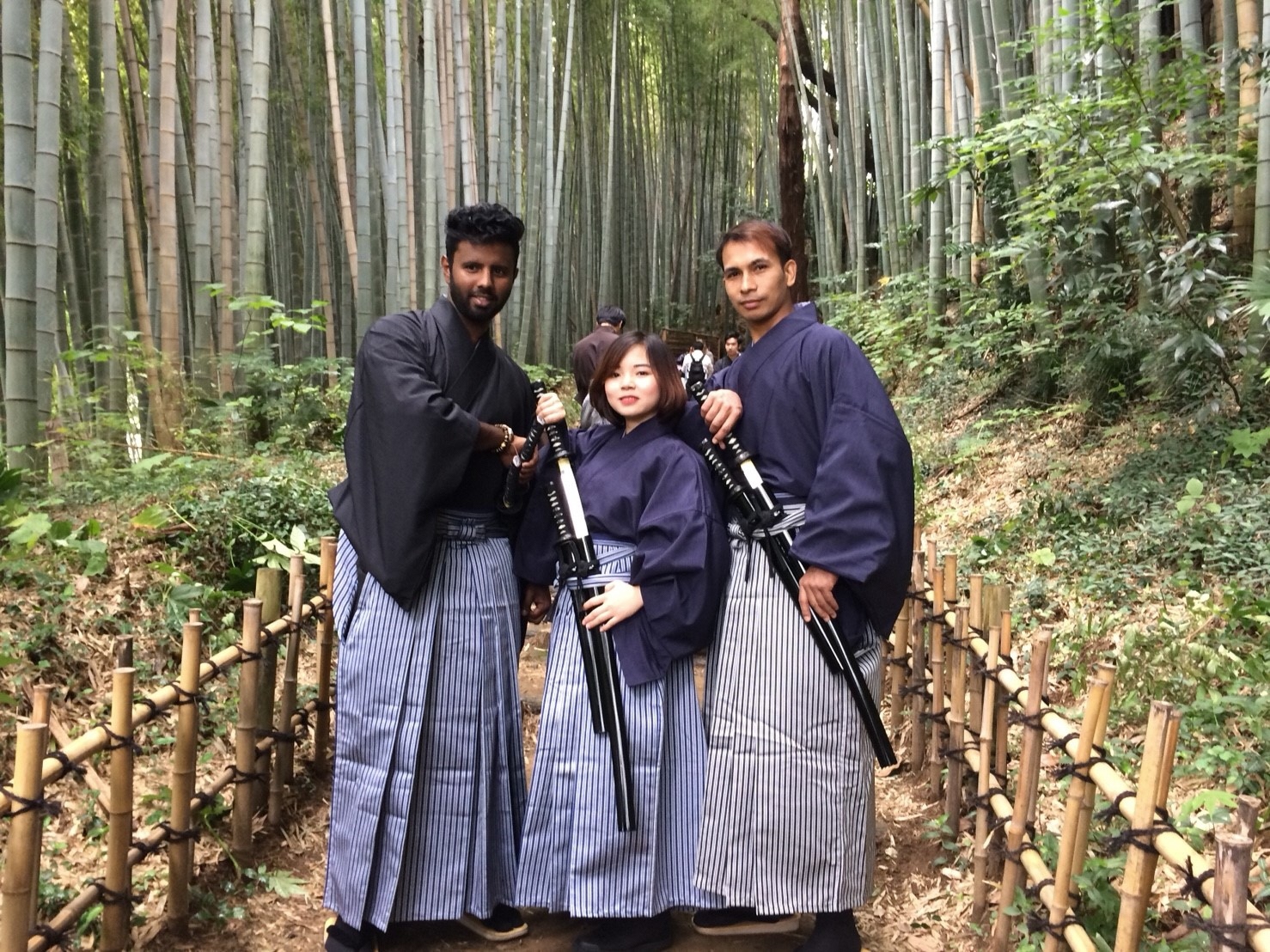 ひよどり坂で、袴を着た女性と外国の男性が腰に刀を差しポーズをとっている写真