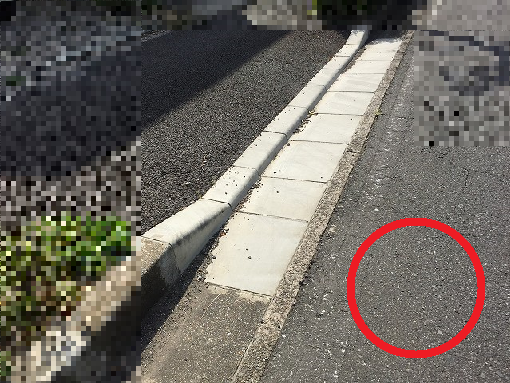 切り下げされた道路脇に赤丸の印がある写真