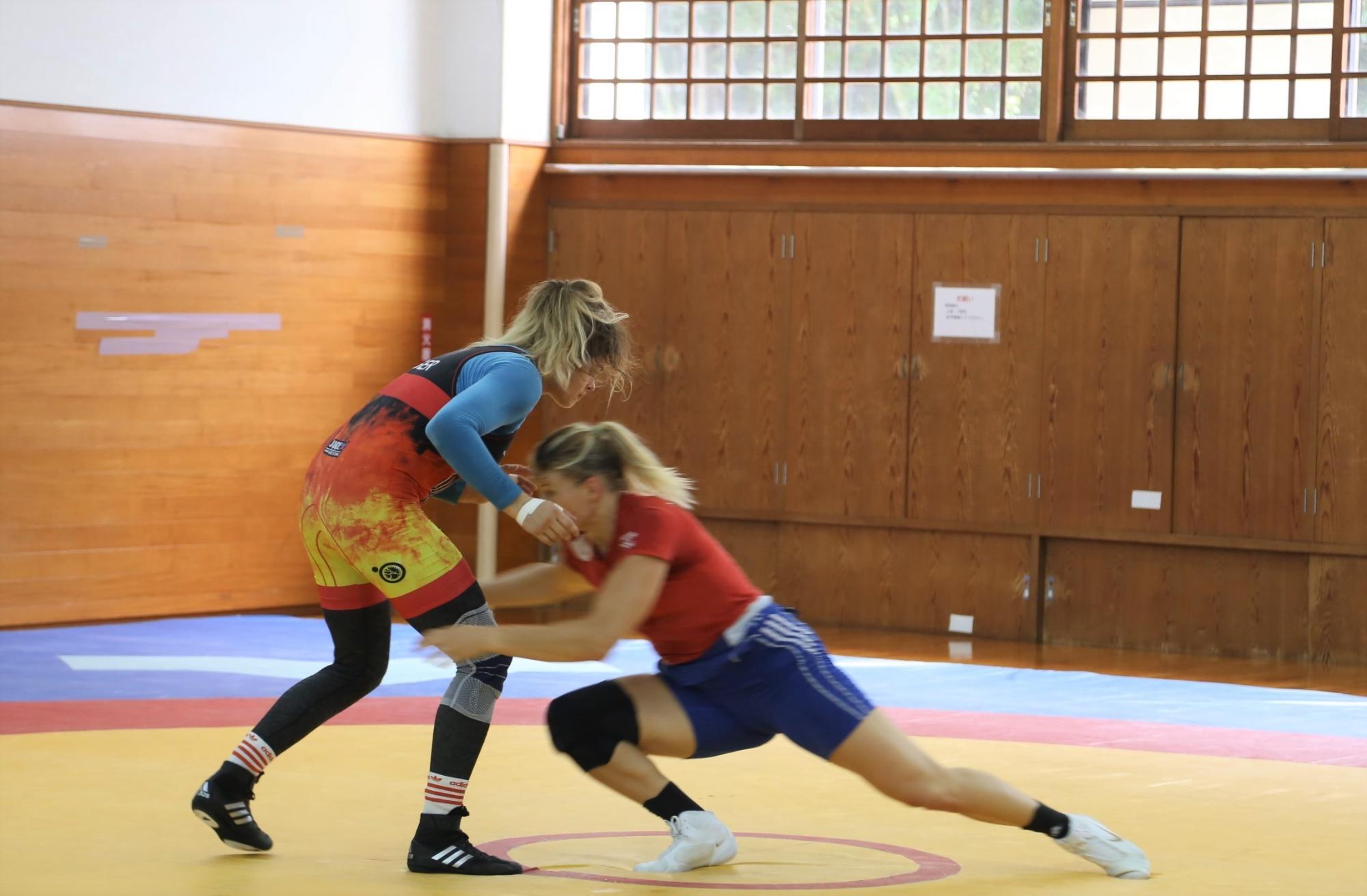 アナ・シェル選手、アリーネ・フォッケン選手が向かいあってレスリングの練習をしている写真