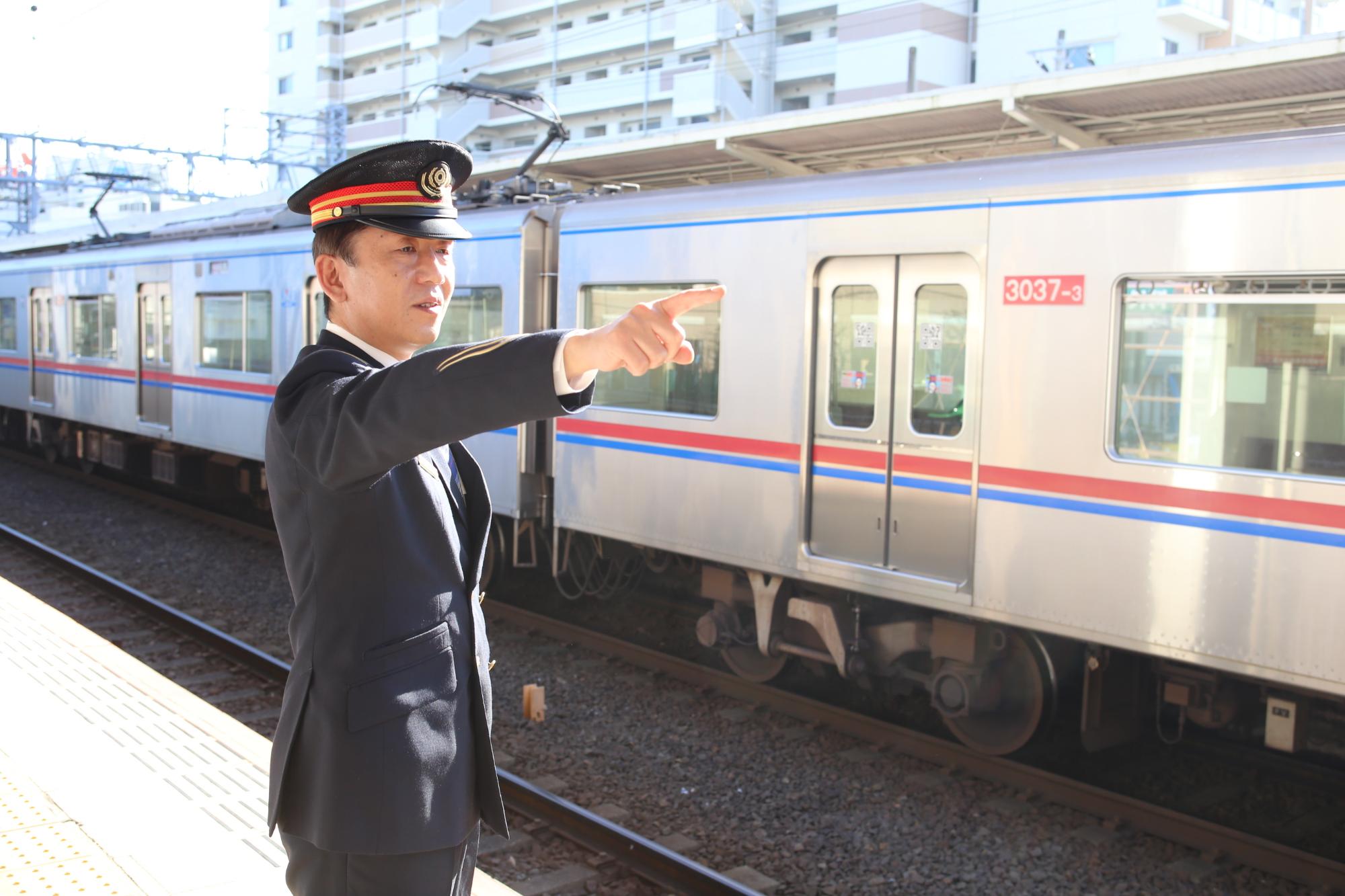 車掌さんがホームに立ち、右側を指さししている写真 魅力発信サイト「サクライク」へリンク