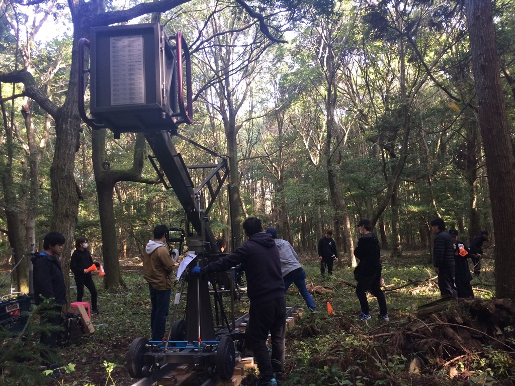 森の中に撮影用のクレーンが設置され、撮影を行っている様子の写真