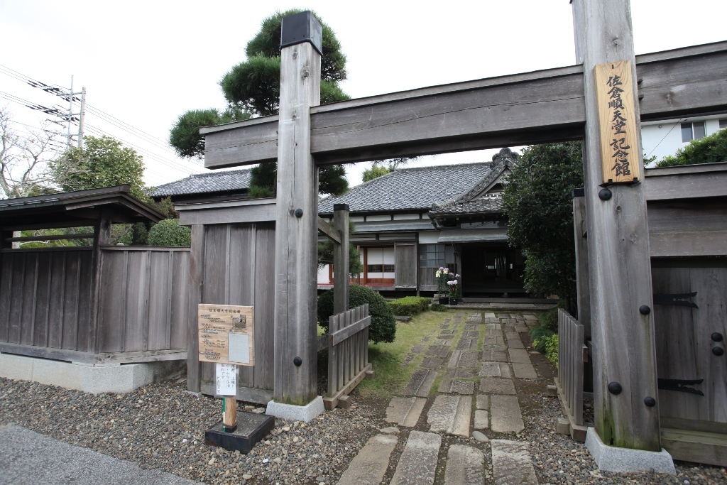 佐倉順天堂記念館の入り口にある古い木造のおおきな門と奥に見える佐倉順天堂記念館の写真